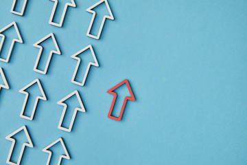 top view of red pointer near diagonal rows with white arrows on blue background