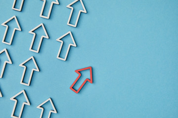top view of diagonal rows with white arrows with red pointer on blue background