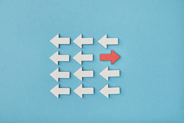 top view of white arrows with opposite red pointer on blue background