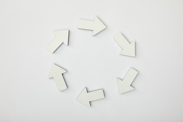top view of white arrows in circle on grey background