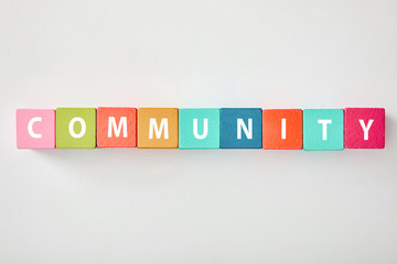 top view of community lettering made of multicolored cubes on grey background