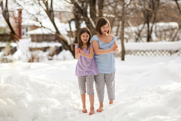 Fototapeta na wymiar Happy girls children in snow barefoot, health care