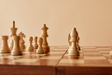 chess on wooden chess board and beige background