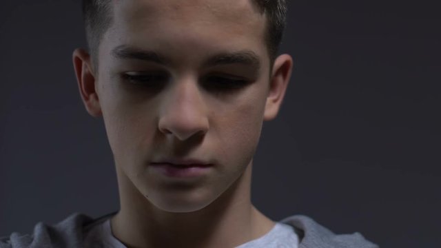 Melancholic teenager suffering depression looking down, psychological trauma