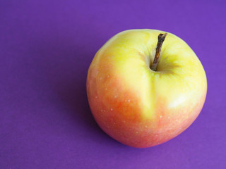 Big ripe red yellow apples on purple background