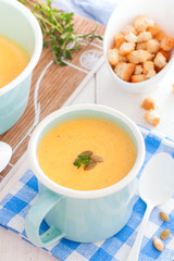 Pumpkin soup in a blue enameled mug, selective focus
