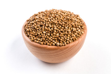 coriander seeds  in wooden bowl isolated on white background.