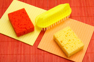 Color synthetic sponges, microfiber napkins and brush for cleaning on bamboo.
