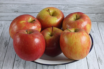 Red apples on white wooden background