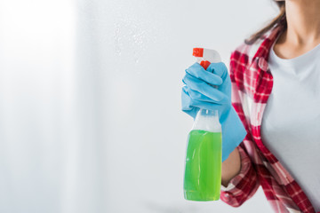 partial view of african american woman holding spray bottle on white background