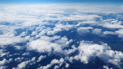 Flying over picturesque white clouds on the deep blue sky. Beautiful moving clouds view from airplane window. Traveling through clear blue cloudscape.