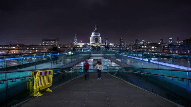 People crossing the Millennium Bridge linking the City of London with the South Bank between St Paul Cathedral and Tate Modern art gallery