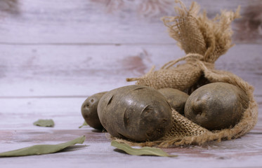 View of the potatoes lying on the table and in the potato sack.
