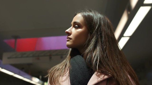 Young woman looking around, standing in spacious hall of big business centre