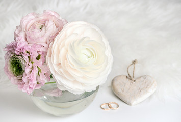 Wedding composition. A gentle picture for a story or a blog. Pink roses, heart, rings and a fluffy rug.  Flat lay. Copy space.
