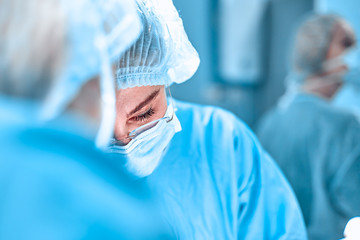 surgery, medicine and people concept - group of surgeons at operation in operating room at hospital