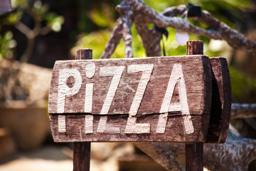 An advertising Pizza on a wooden Board