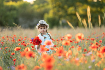 Portrait of emotional little girl in red poppy field spring summer inspiration