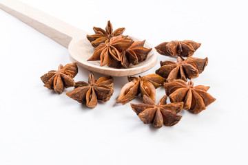 anise stars in wooden spoon isolated on white background. Closeup.