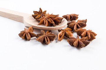 anise stars in wooden spoon isolated on white background. Closeup.