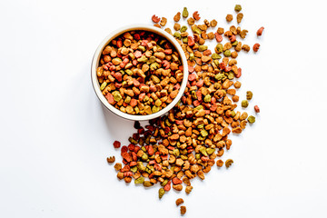 dry cat food in bowl on white background top view