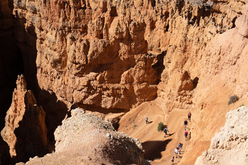Hikers traverse the Queens Loop Trail in Bryce Canyon National Park and walk among the hoodoos