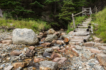 Wooden stairs path along the rock and a small river