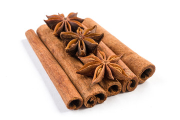 anise stars laying on cinnamon sticks isolated on white background.