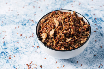 fried red rice with chicken meat in a bowl