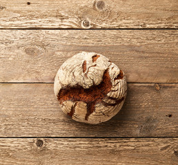 Round rye bread on a wooden table. Bakery concept.