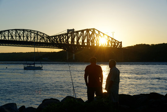 People fishing from Parc de la Marina-de-la-Chaudi&egrave;re, St-Romuald, Quebec, with the St Lawrence Rier in Pont du Quebec behind