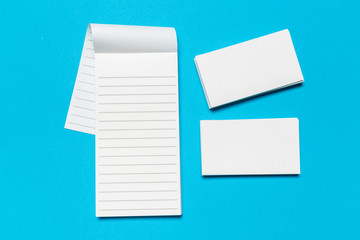 Blank white business cards on blue background. Mockup for branding identity.