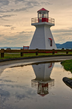The lighthouse at Carleton, Gaspesie, Quebec reflected in a puddle after a summer storm