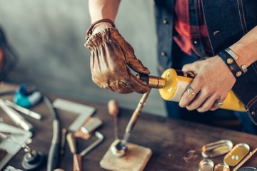 man repairing the torch at workplace, close up cropped photo