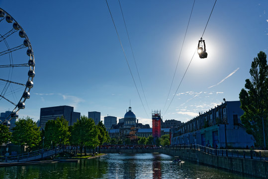 A person descending the zipline in Montreal Old Port with La Grande Roue de Montreal behind