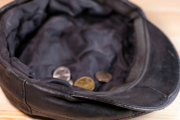 cap with a few alms coins