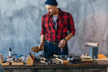 craftsman putting glowes on the desk after repairing the jewelry. close up photo