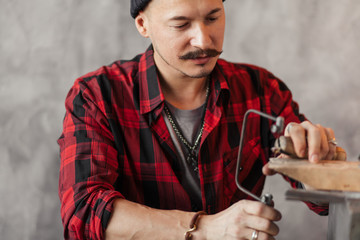 serious man testing the new fretsaw. close up photo. business