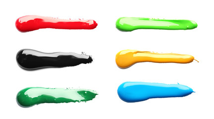 Set with abstract brushstrokes of different bright paints on white background, top view