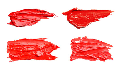 Set with abstract brushstrokes of red paint on white background, top view