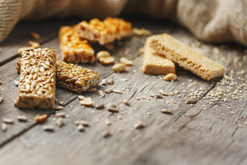 Assorted kozinaki, on old vintage background, with burlap fabric. Country style. Delicious sweets from the seeds of sunflower, sesame and peanuts, covered with shiny glaze.