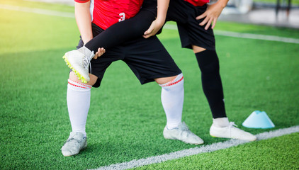 Fototapeta premium boy soccer players stretch muscles with coach
