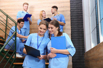 Young smiling medical students in university hall