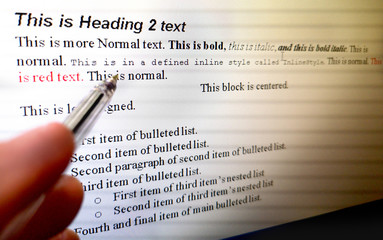 hand with pen indicate text formatting rules on word processor software on computer screen