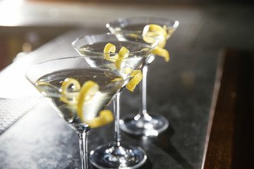 Glasses of lemon drop martini cocktail on bar counter, closeup. Space for text