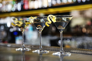 Glasses of lemon drop martini cocktail on bar counter. Space for text