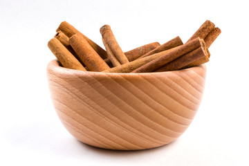 cinnamon sticks  in wooden bowl isolated on white background