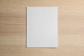Brochure with blank cover on wooden background, top view. Mock up for design