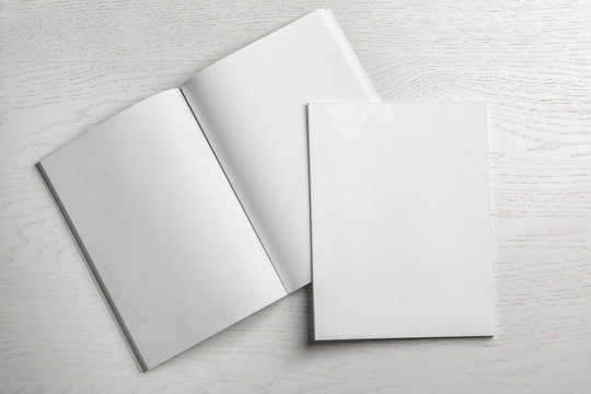 Open and closed blank brochures on wooden background, top view. Mock up for design