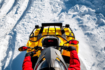 Young man in red warm winter clothes and black helmet on the ATV 4wd quad bike stand in heavy snow with deep wheel track. Moto winter sports. Top view. © Screaghin